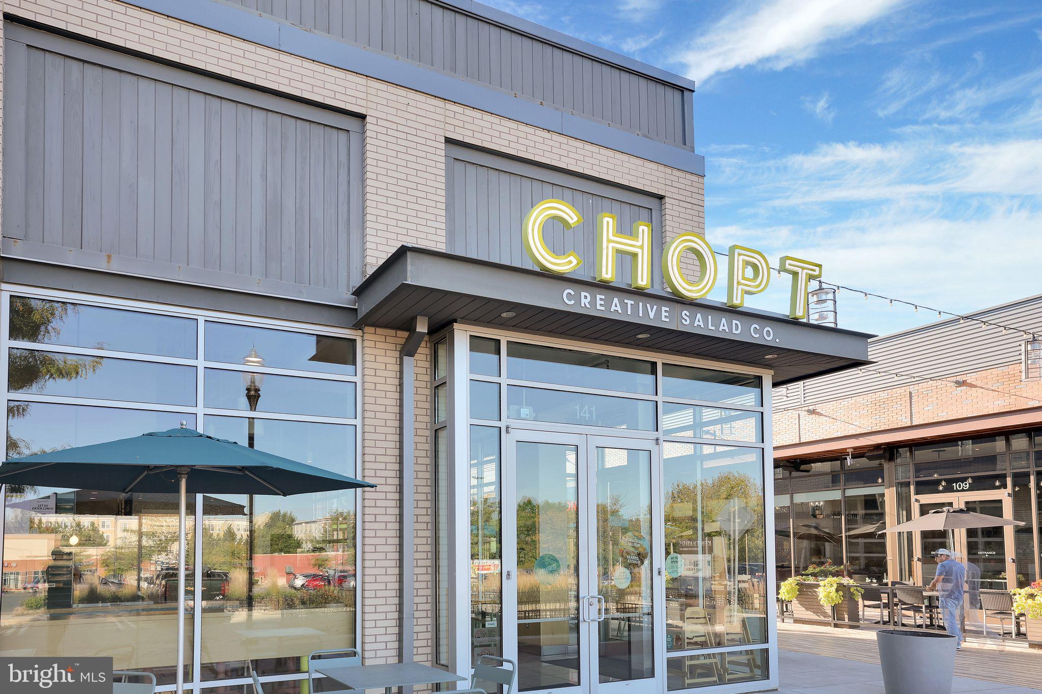 111 A Chevy Chase Street, Unit 111A Gaithersburg, MD 20878 - Photo 43 of 47 a front view of a building with glass windows and a table