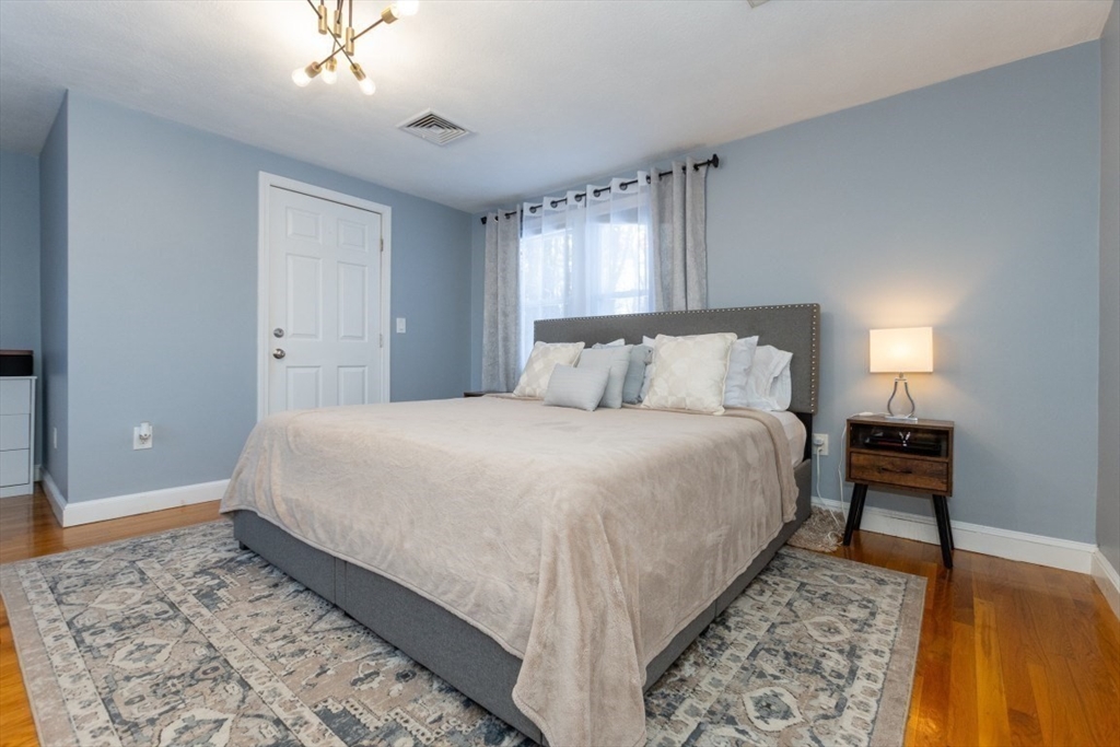 9 Bruce Street Burlington, MA 01803 - Photo 14 of 38 a bedroom with a bed lamp on desk and a window
