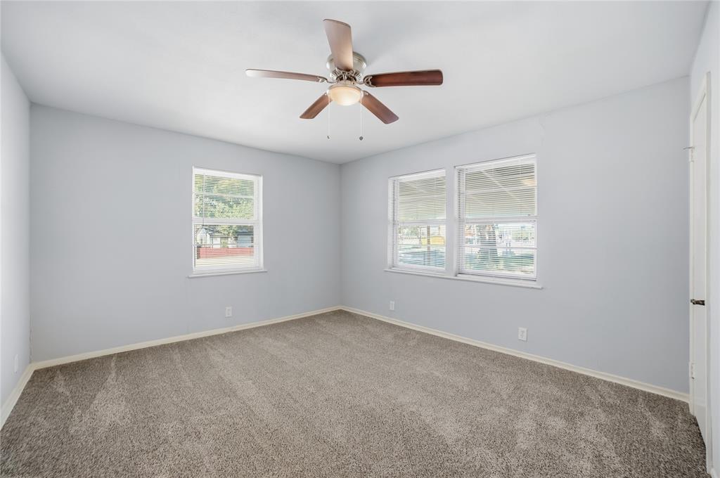 2926 North Prairie Creek Road Dallas, TX 75227 - Photo 18 of 22 an empty room with windows and ceiling fan