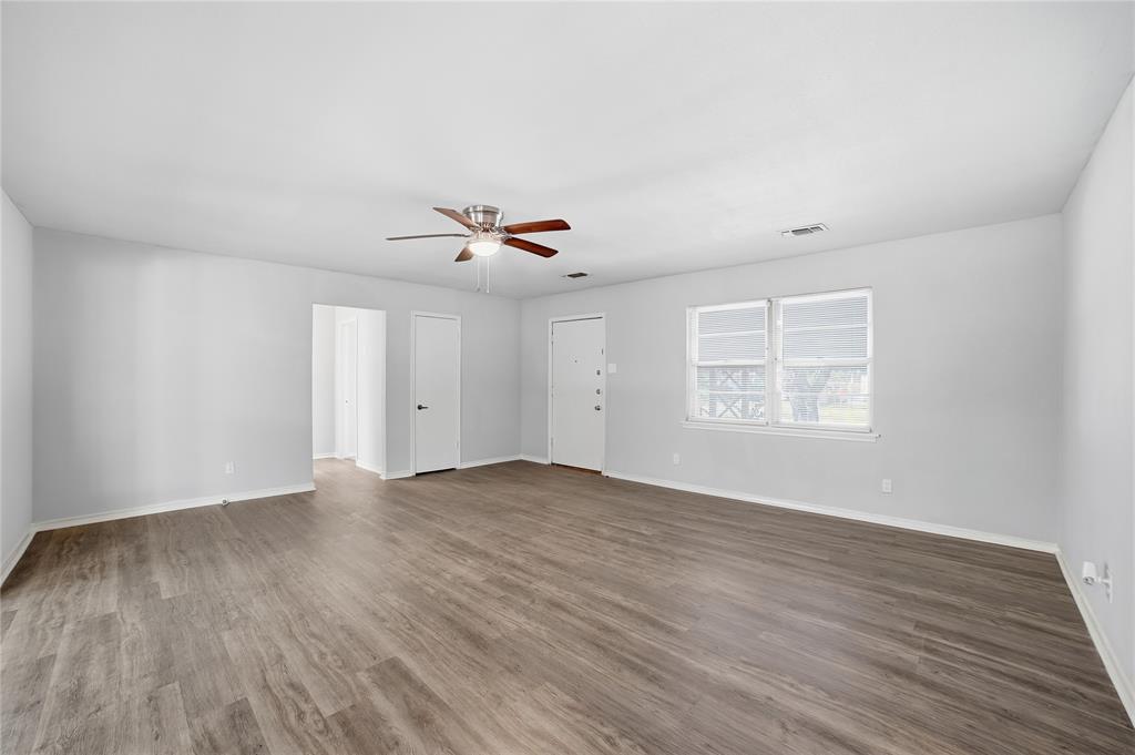 2926 North Prairie Creek Road Dallas, TX 75227 - Photo 2 of 22 a view of an empty room with wooden floor and a window