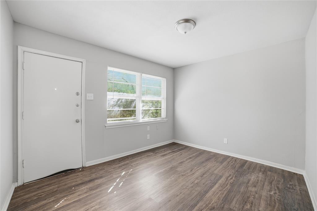 2926 North Prairie Creek Road Dallas, TX 75227 - Photo 4 of 22 an empty room with wooden floor and windows