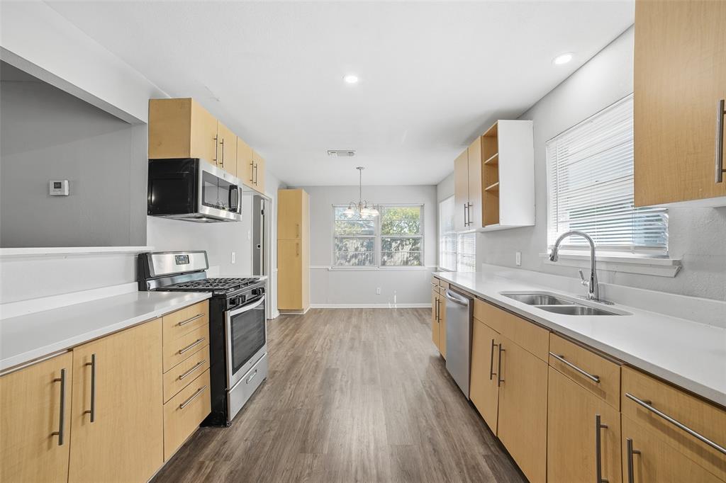 2926 North Prairie Creek Road Dallas, TX 75227 - Photo 8 of 22 a kitchen with stainless steel appliances granite countertop a sink stove and refrigerator