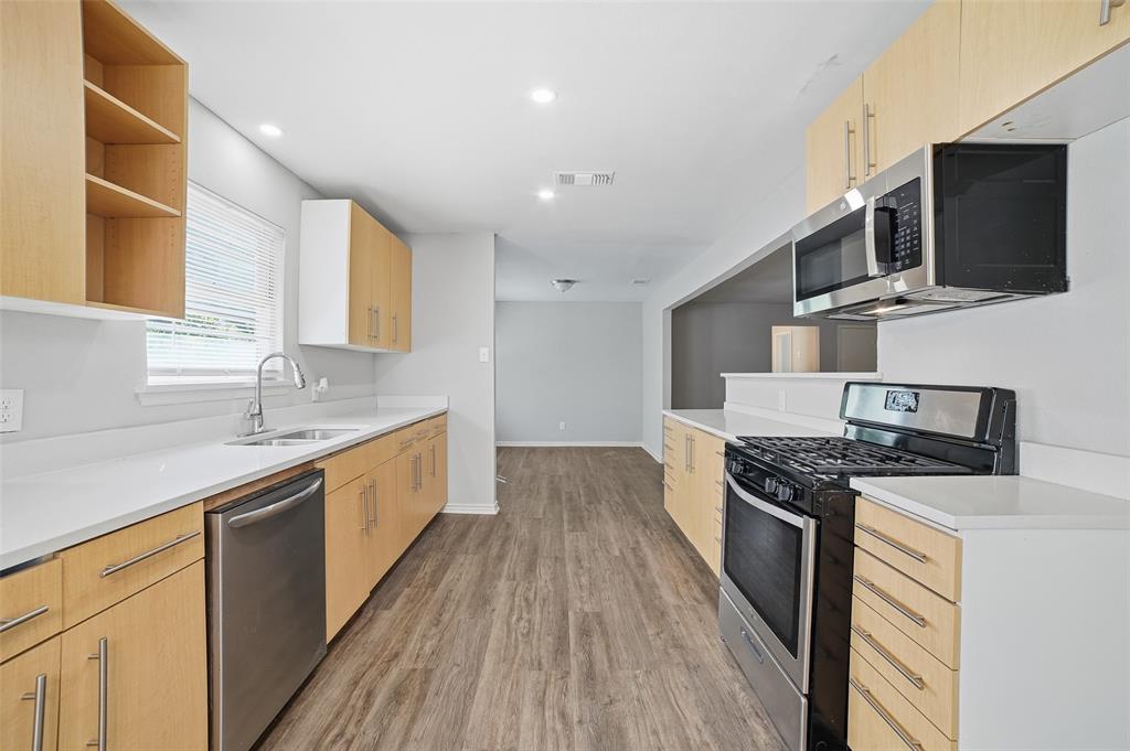 2926 North Prairie Creek Road Dallas, TX 75227 - Photo 9 of 22 a kitchen with stainless steel appliances granite countertop a sink stove and microwave