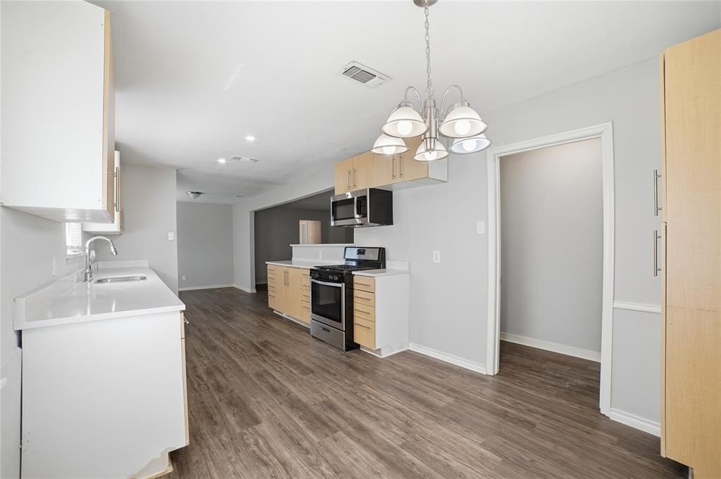 2926 North Prairie Creek Road Dallas, TX 75227 - Photo 10 of 22 a kitchen with wooden floor and a stove