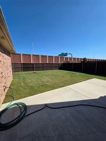 a view of a backyard with lawn chairs