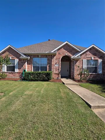 a front view of a house with a garden and yard