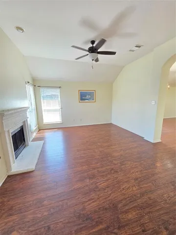 a view of empty room with wooden floor and fireplace
