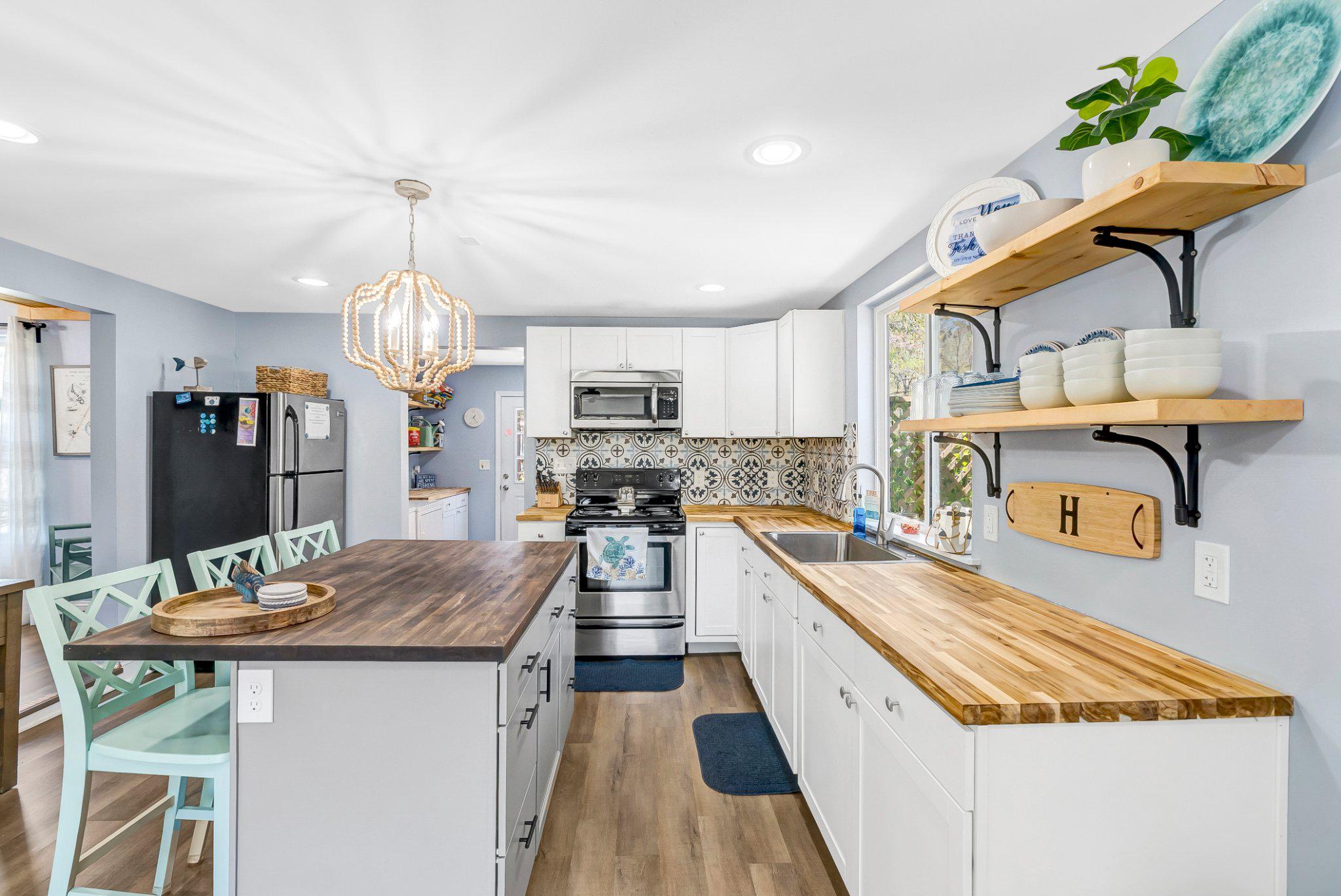 782 Mt Ararat Road Clarksville, VA 23927 - Photo 10 of 28 a large kitchen with stainless steel appliances kitchen island granite countertop a table chairs in it and wooden floors