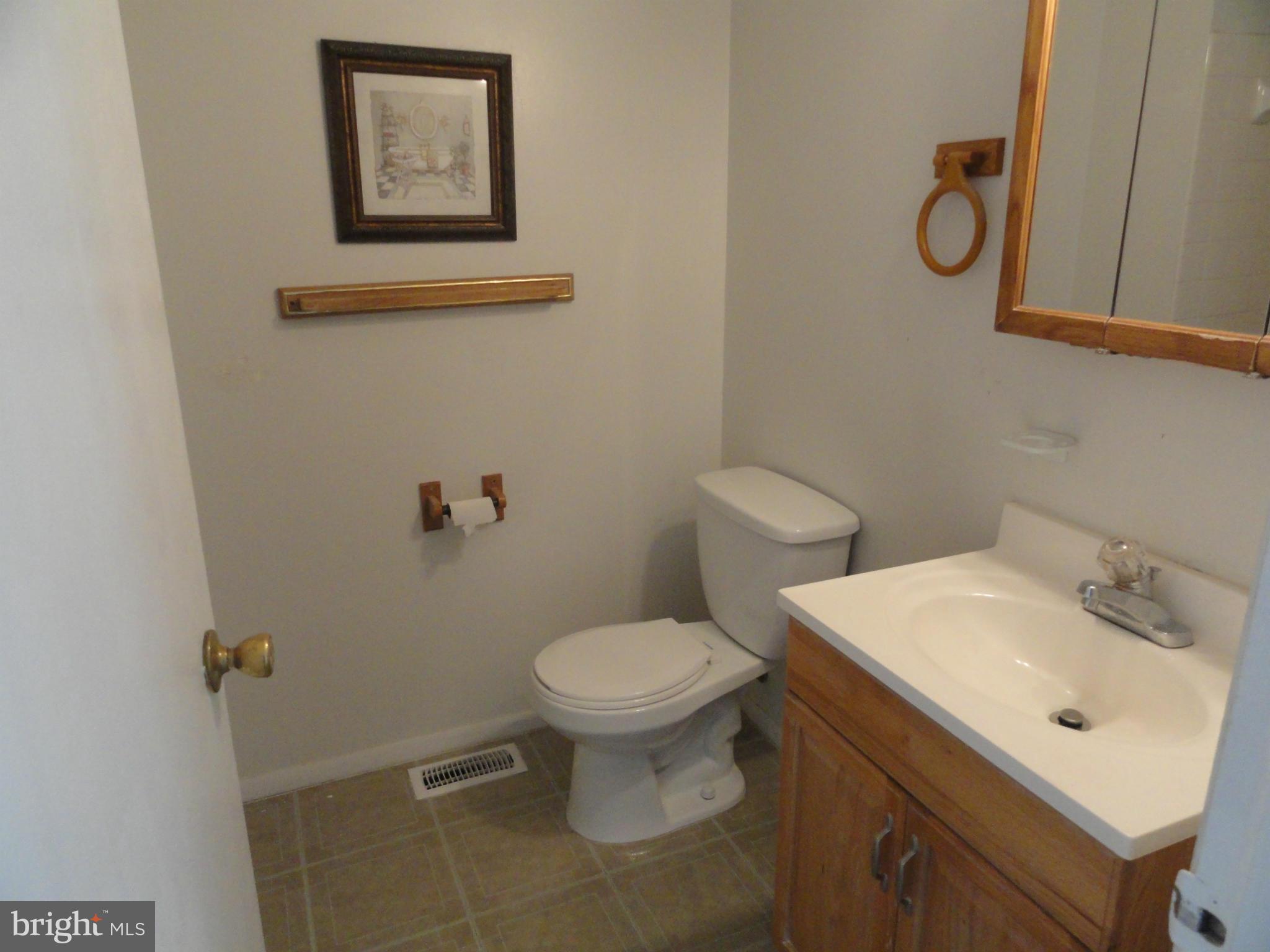 39 Coliston Road, Unit B Reisterstown, MD 21136 - Photo 10 of 20 a bathroom with a toilet sink vanity and mirror