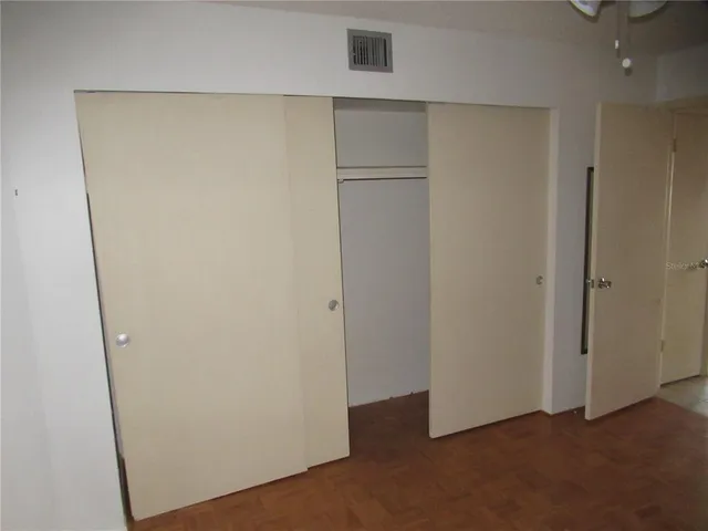 an empty room with fan and entrance