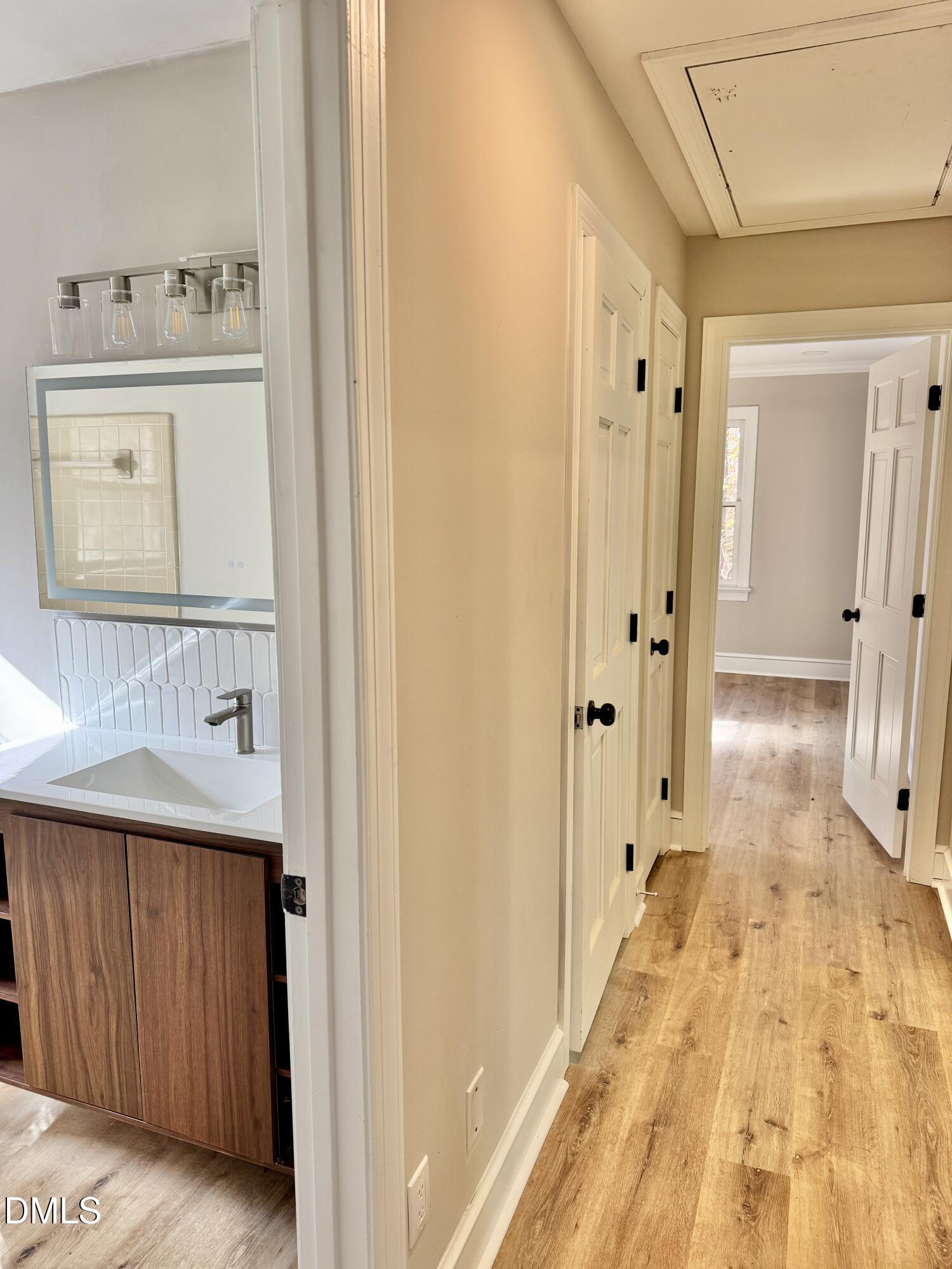 3412 Hackney Court Raleigh, NC 27613 - Photo 16 of 27 a view of a hallway to a bedroom with wooden floor and cabinet