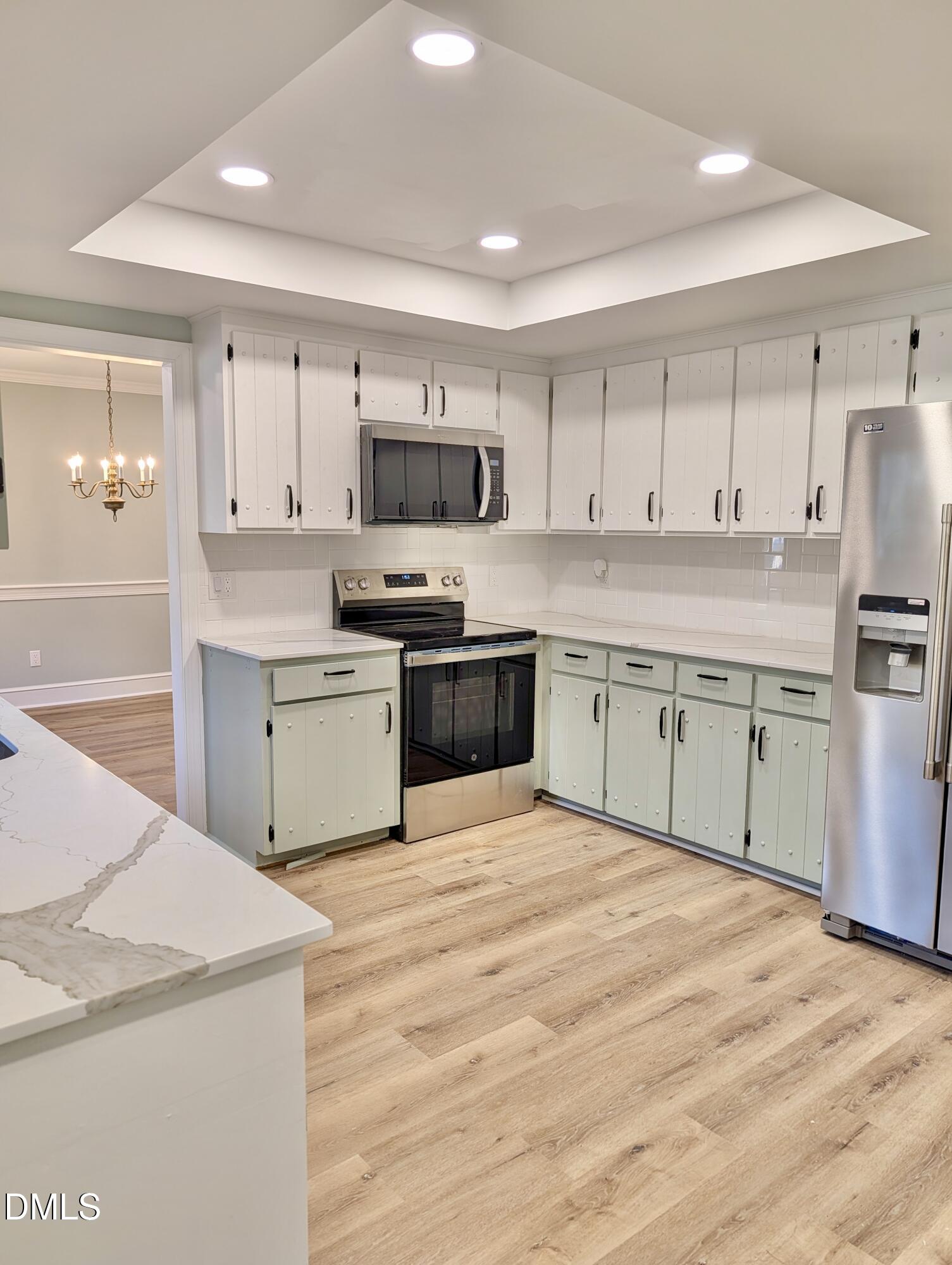 3412 Hackney Court Raleigh, NC 27613 - Photo 27 of 27 a kitchen with stainless steel appliances granite countertop a stove top oven a sink dishwasher and white cabinets with wooden floor