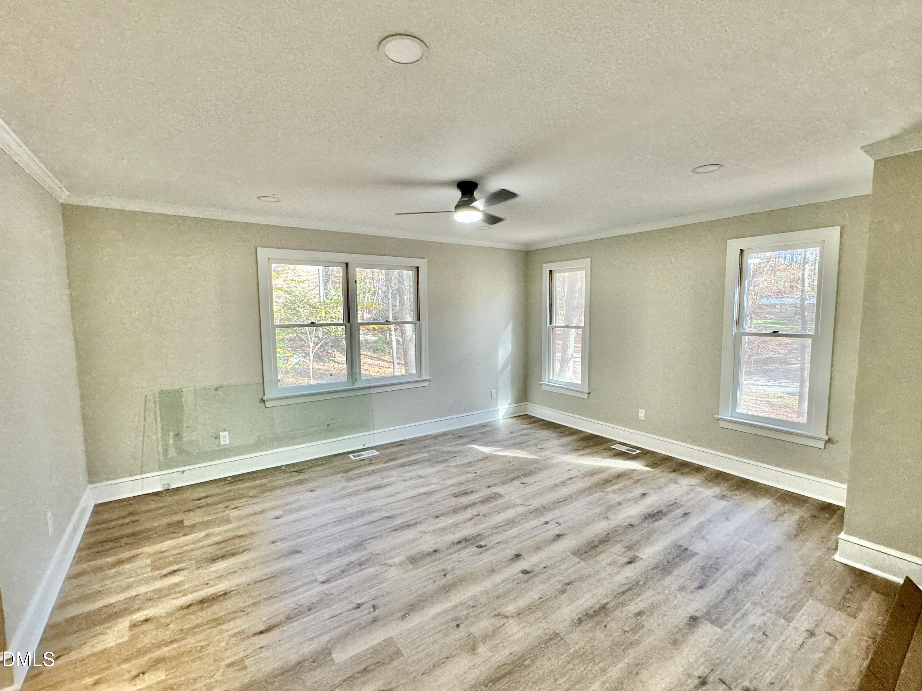 3412 Hackney Court Raleigh, NC 27613 - Photo 6 of 27 an empty room with wooden floor and windows
