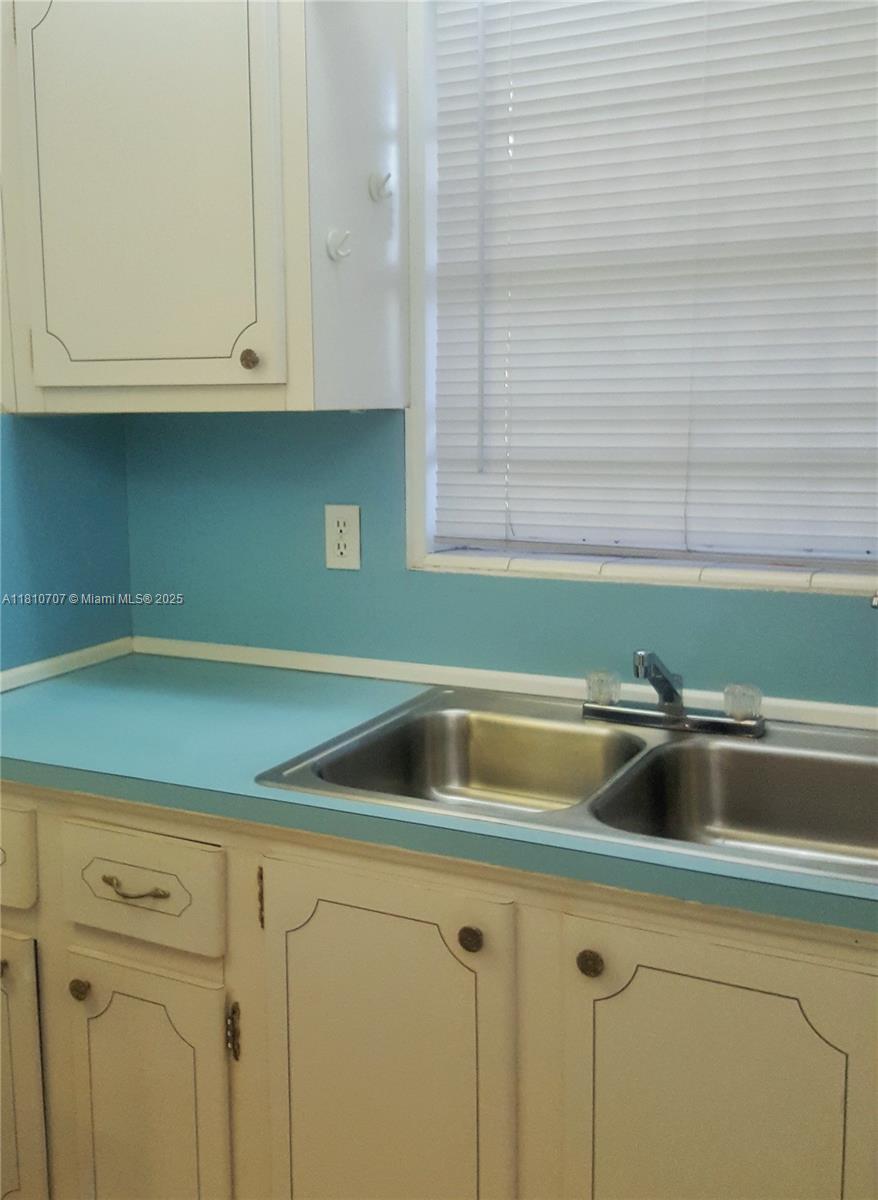 19080 Northeast 3rd Court, Unit 318 Miami, FL 33179 - Photo 6 of 8 a kitchen with a sink and cabinets
