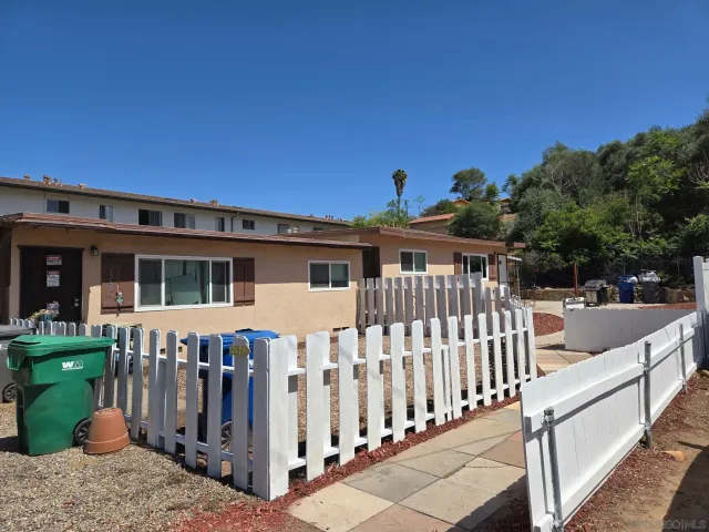 a view of a house with wooden fence