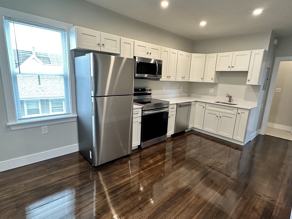 a kitchen with stainless steel appliances granite countertop a refrigerator stove top oven and sink