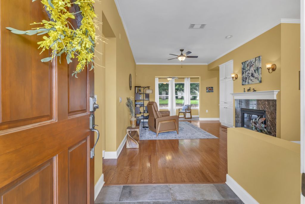 144 Cattle Trail Way Georgetown, TX 78633 - Photo 3 of 37 Step into a welcoming living space featuring gleaming hardwood floors, a cozy fireplace, and abundant natural light.