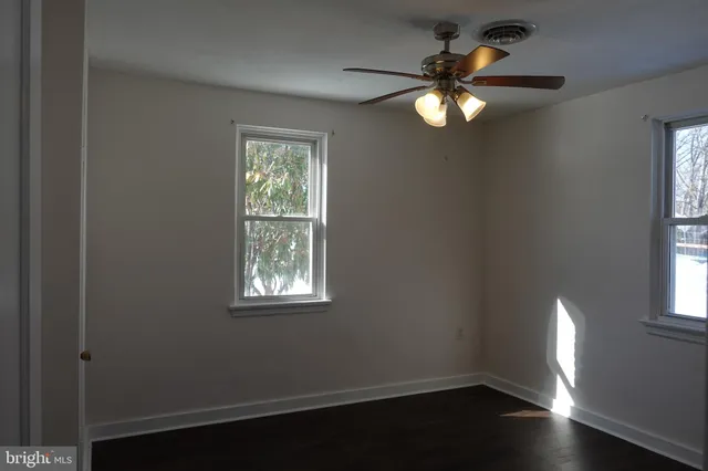 a view of wooden floor and a chandelier fan in a room