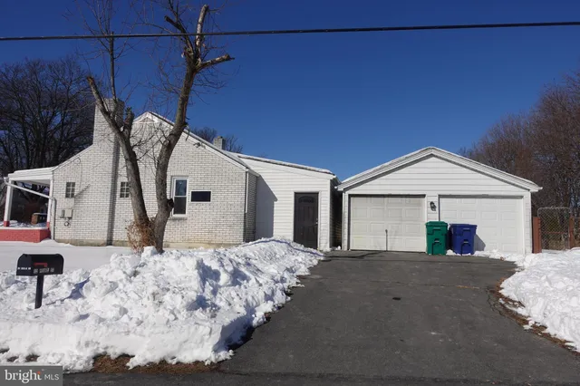 a view of a white house next to a yard
