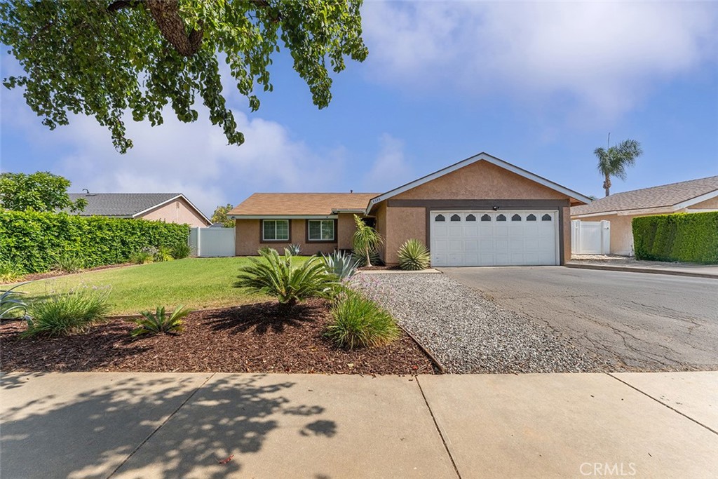 Front of home with cars photoshopped out from driveway.
