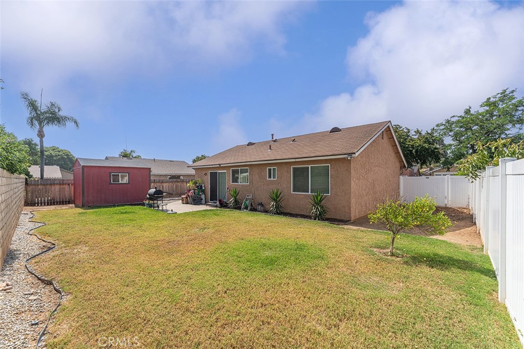 9595 Altadena Drive Riverside, CA 92503 - Photo 18 of 31 Spacious backyard with block wall and vinyl fencing. Spacious barn shed in distance. Right window belongs to the primary bedroom.
