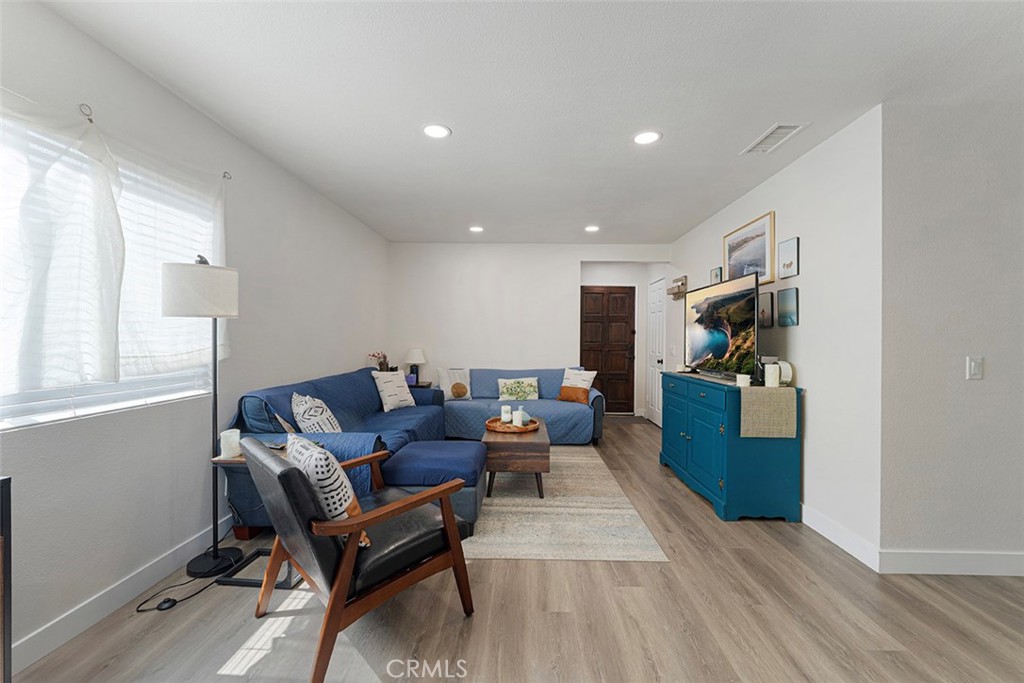 9595 Altadena Drive Riverside, CA 92503 - Photo 4 of 31 Vinyl plank flooring, recessed lighting. Entrance in the middle. Hallway to the left. Standing from dining/kitchen area.