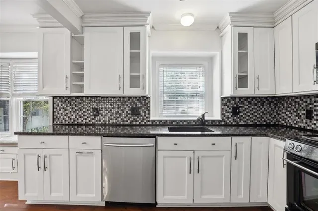 a kitchen with granite countertop white cabinets and sink