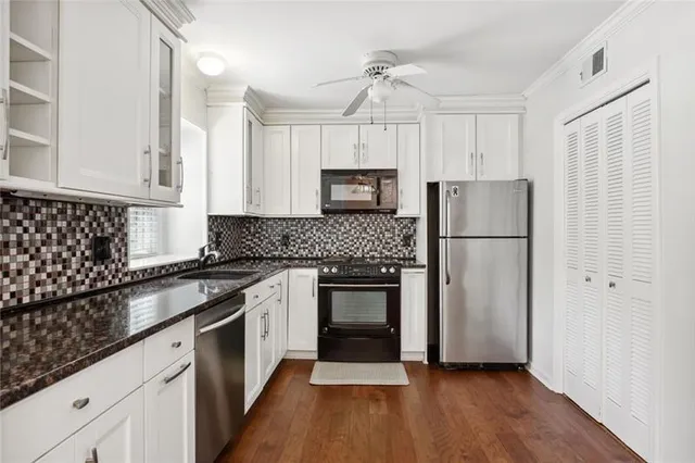 a kitchen with a refrigerator and a stove top oven