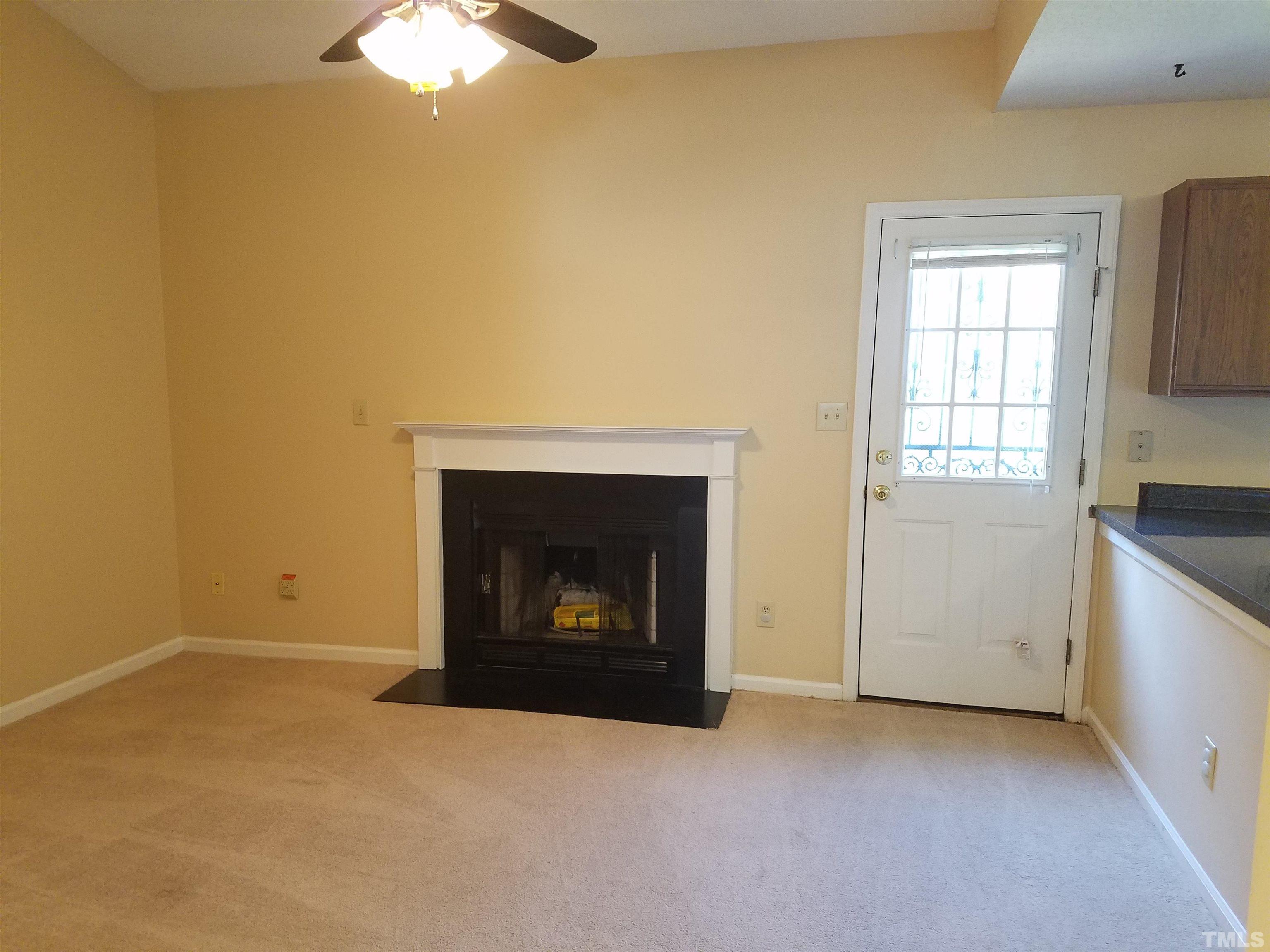 1815 Collier Road Durham, NC 27707 - Photo 5 of 14 a view of an empty room with a fireplace and a window