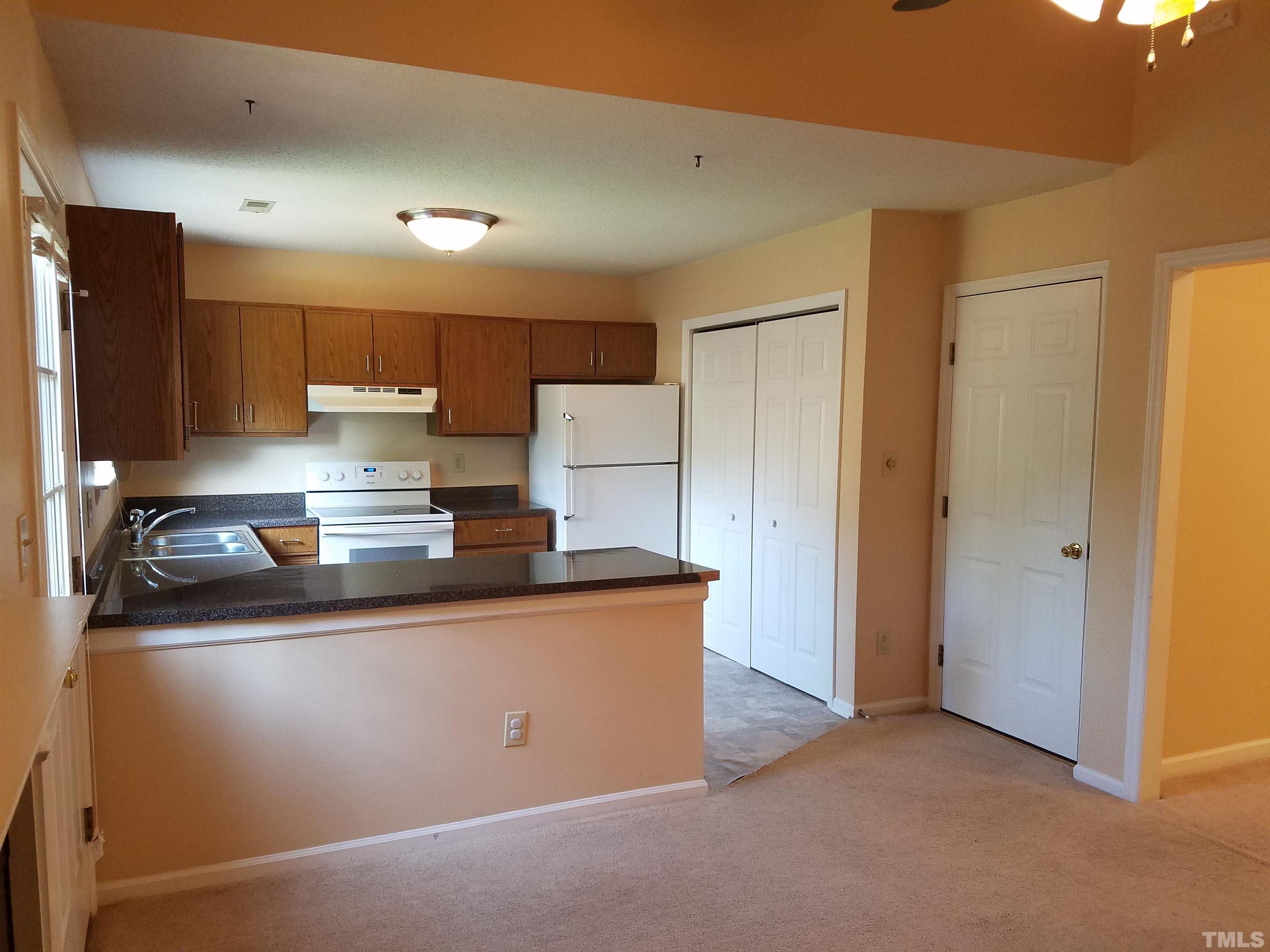 1815 Collier Road Durham, NC 27707 - Photo 6 of 14 a kitchen with stainless steel appliances granite countertop a sink and a refrigerator
