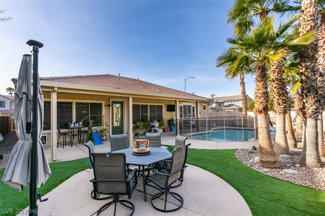 7524 Midnight Rambler Street Las Vegas, NV 89149 - Photo 43 of 51 A private swimming pool and patio area with lush artificial turf and mature palm trees.