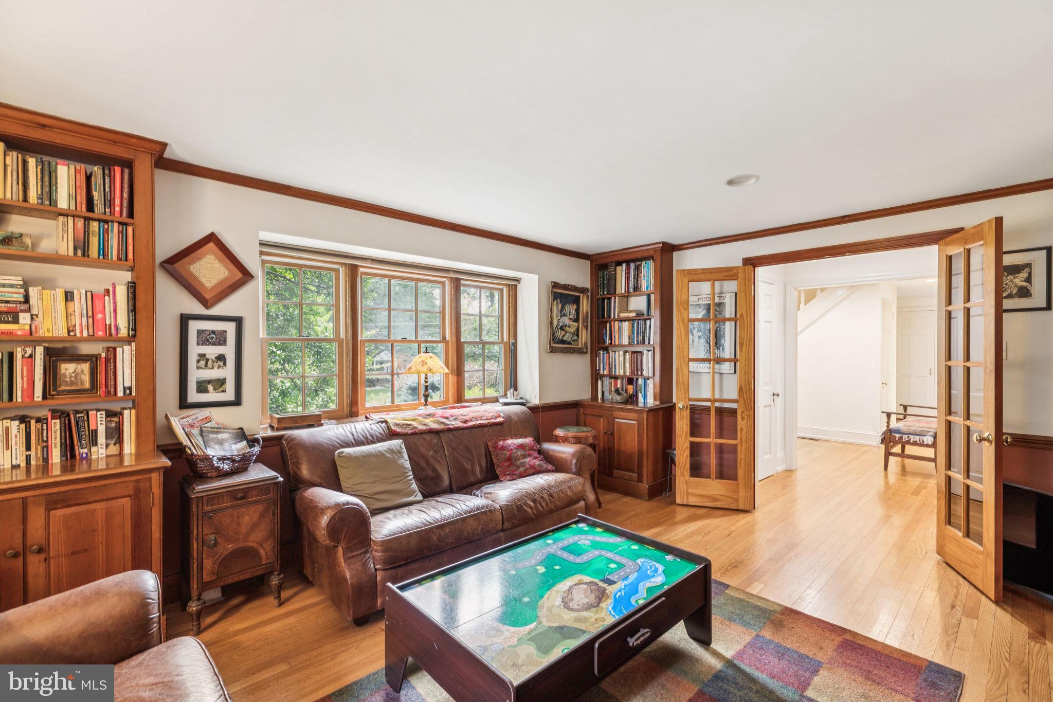 744 Clarendon Road Penn Valley, PA 19072 - Photo 17 of 41 a living room with furniture a bookshelf and a window