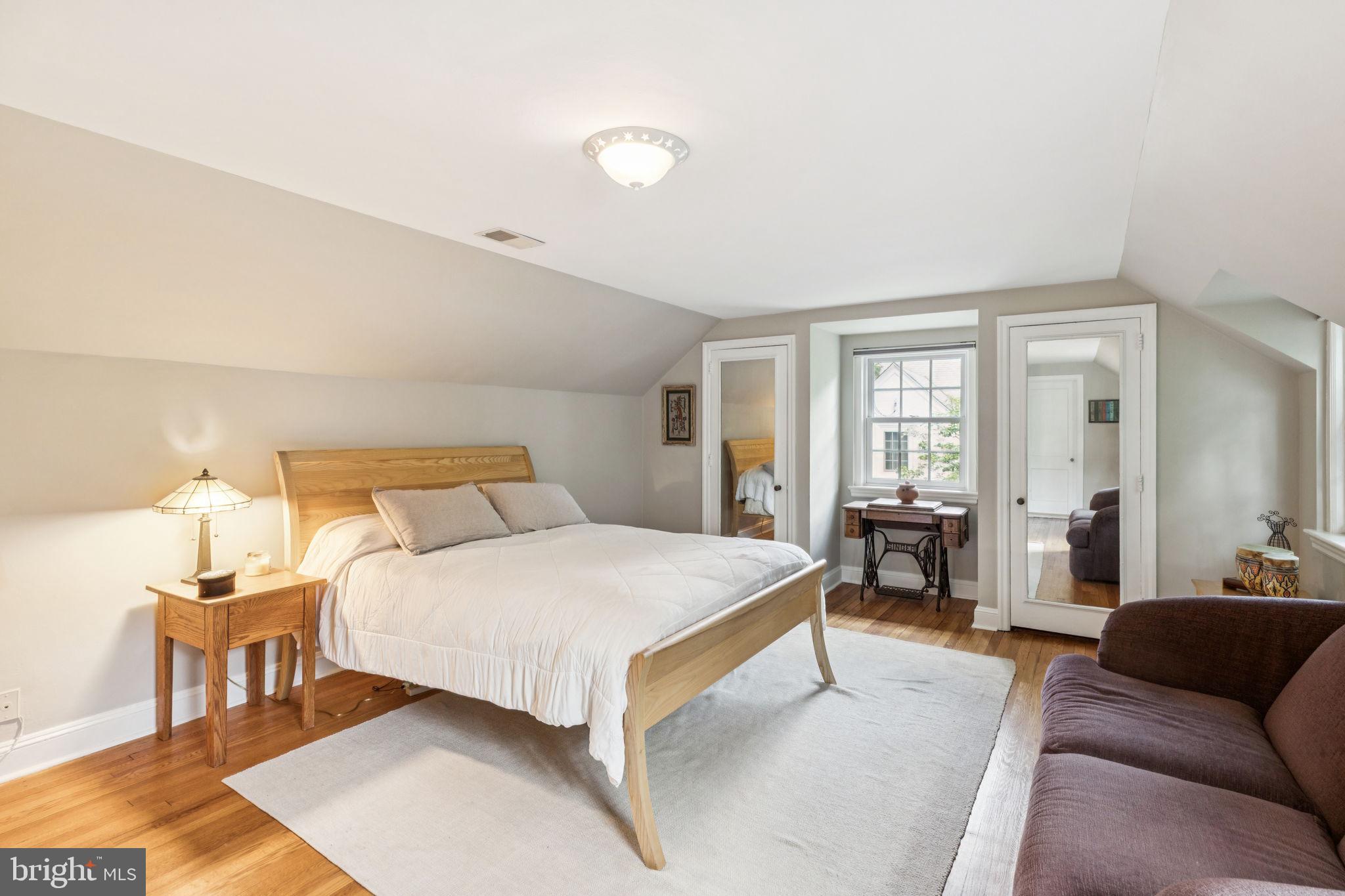 744 Clarendon Road Penn Valley, PA 19072 - Photo 28 of 41 a bedroom with a bed couch and wooden floor
