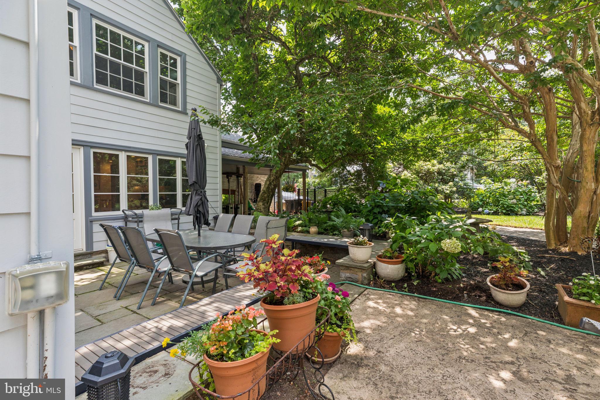 744 Clarendon Road Penn Valley, PA 19072 - Photo 6 of 41 a view of a patio with table and chairs potted plants and large tree