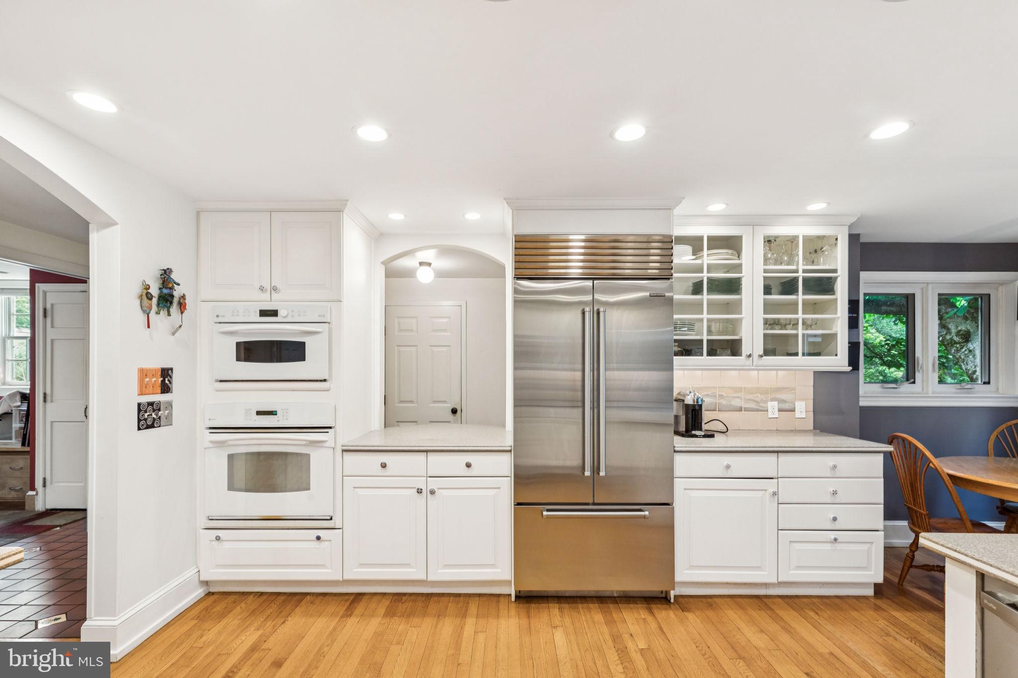 744 Clarendon Road Penn Valley, PA 19072 - Photo 10 of 41 a kitchen with stainless steel appliances kitchen island wooden floor and white cabinets