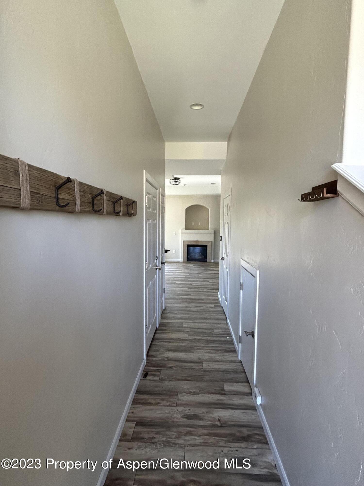 710 West 24th Street Rifle, CO 81650 - Photo 3 of 19 a view of a hallway with wooden floor and staircase
