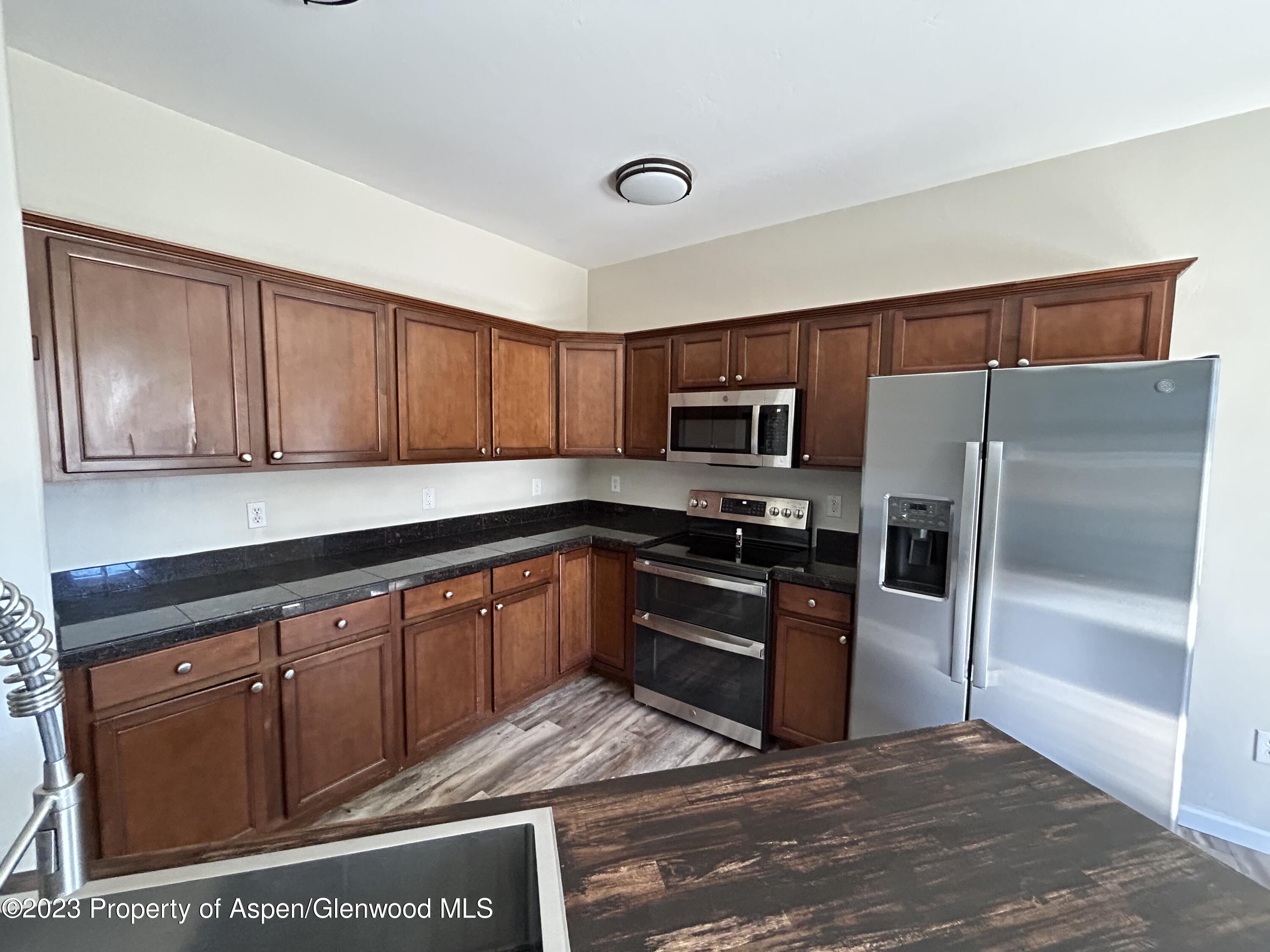 710 West 24th Street Rifle, CO 81650 - Photo 4 of 19 a kitchen with stainless steel appliances granite countertop a refrigerator stove and sink