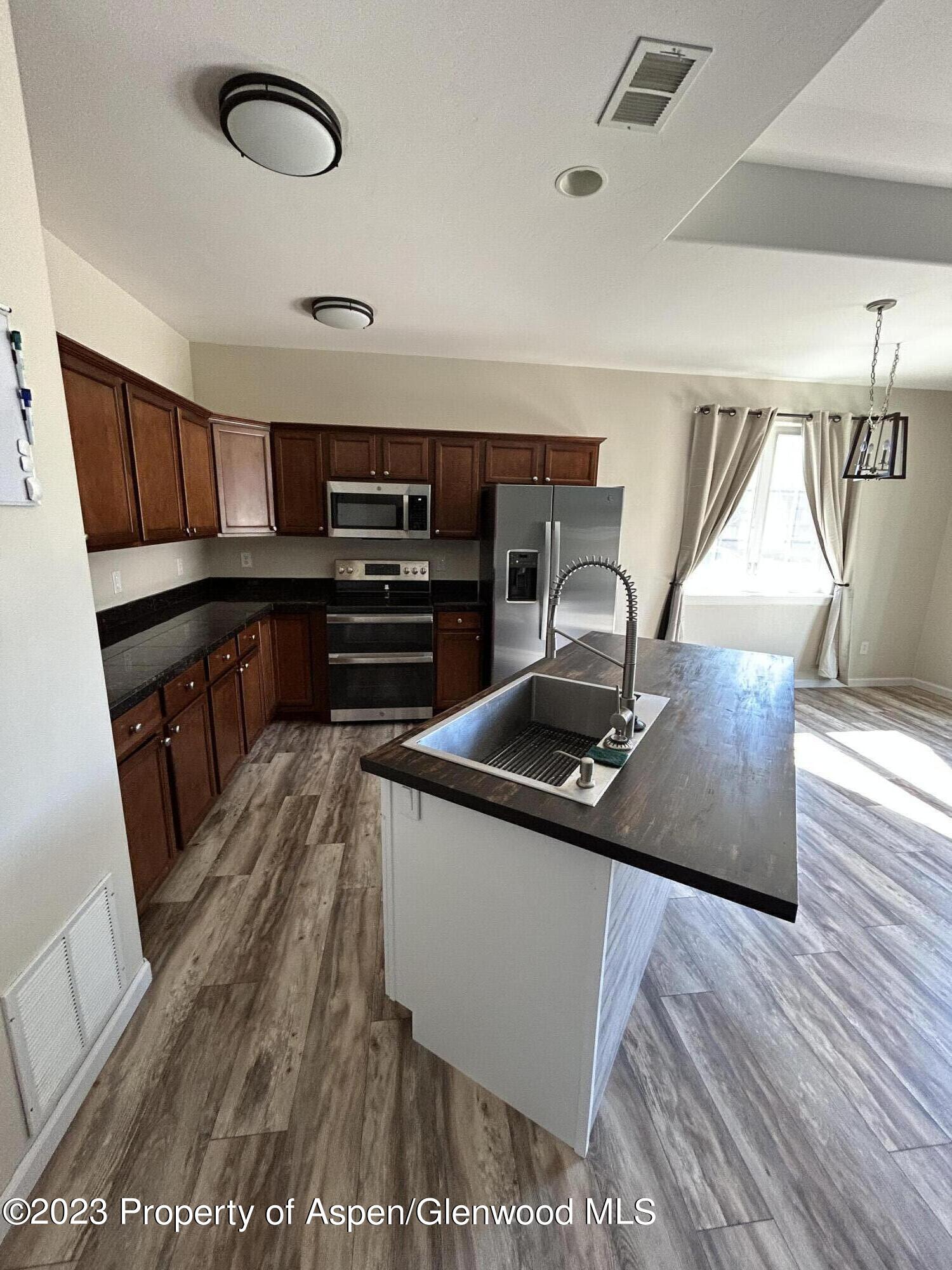 710 West 24th Street Rifle, CO 81650 - Photo 5 of 19 a kitchen with stainless steel appliances granite countertop a sink and a stove