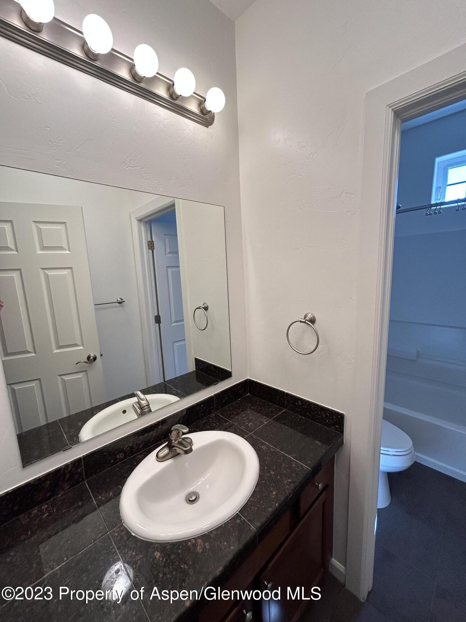 710 West 24th Street Rifle, CO 81650 - Photo 9 of 19 a bathroom with a sink and a mirror