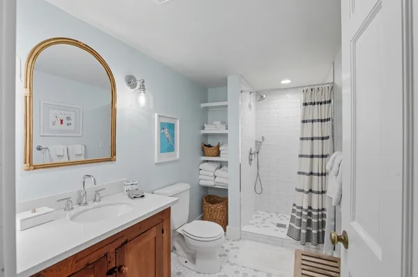 a bathroom with a sink a toilet and shower