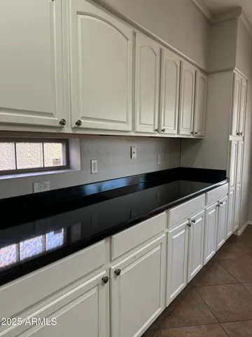 a kitchen with white cabinets and black appliances