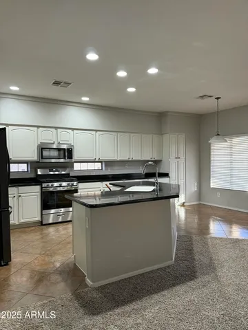 a kitchen with stainless steel appliances granite countertop a sink and stove top oven