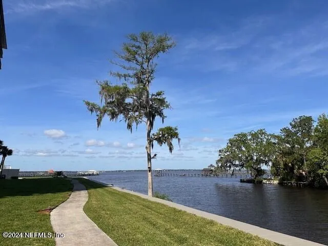 a view of a house with a yard from a lake