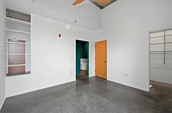 an empty room with a ceiling fan and a window