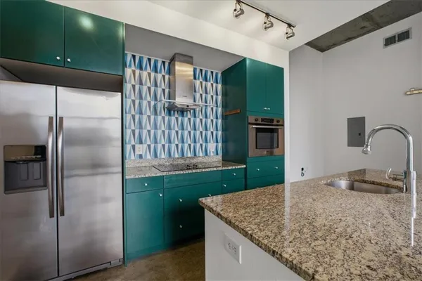 a kitchen with kitchen island a counter top space cabinets and stainless steel appliances