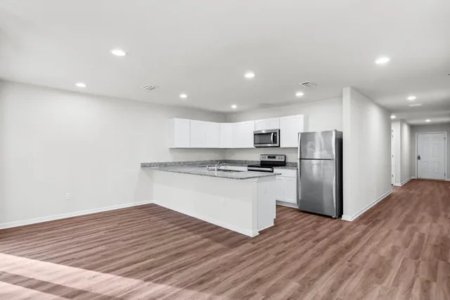 a kitchen with stainless steel appliances granite countertop a refrigerator and a stove top oven