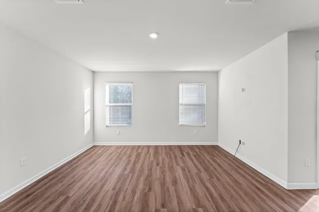 a view of a room with wooden floor and window