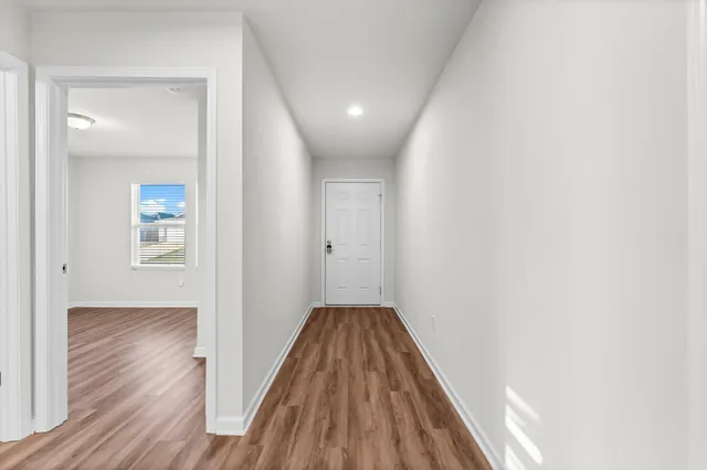 a view of a hallway with wooden floor