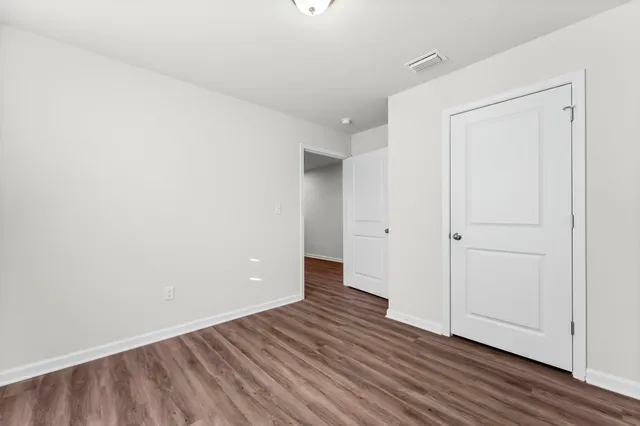 a view of an empty room with wooden floor