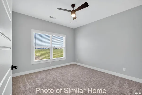 an empty room with closet and a ceiling fan